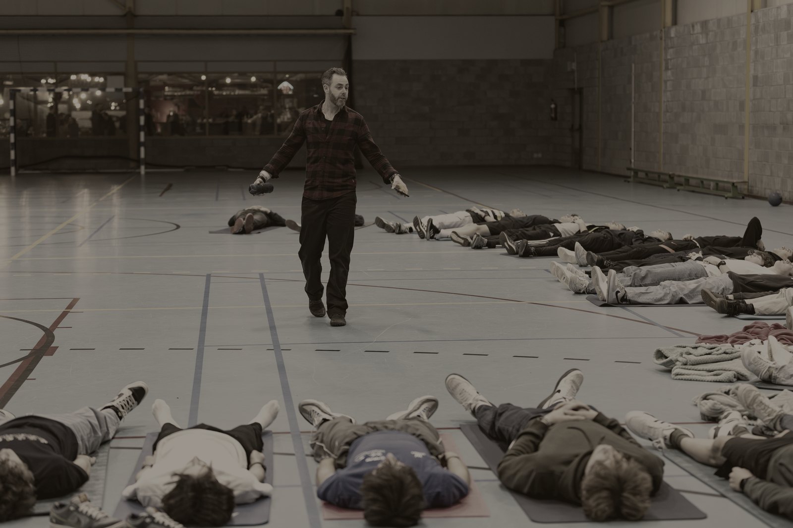 Sven begeleidt een groep die op matten in de zaal ligt te ademen